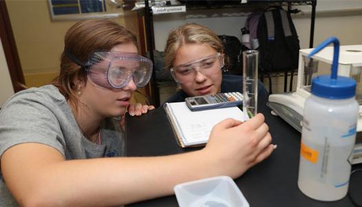 two students work on an experiment in a lab